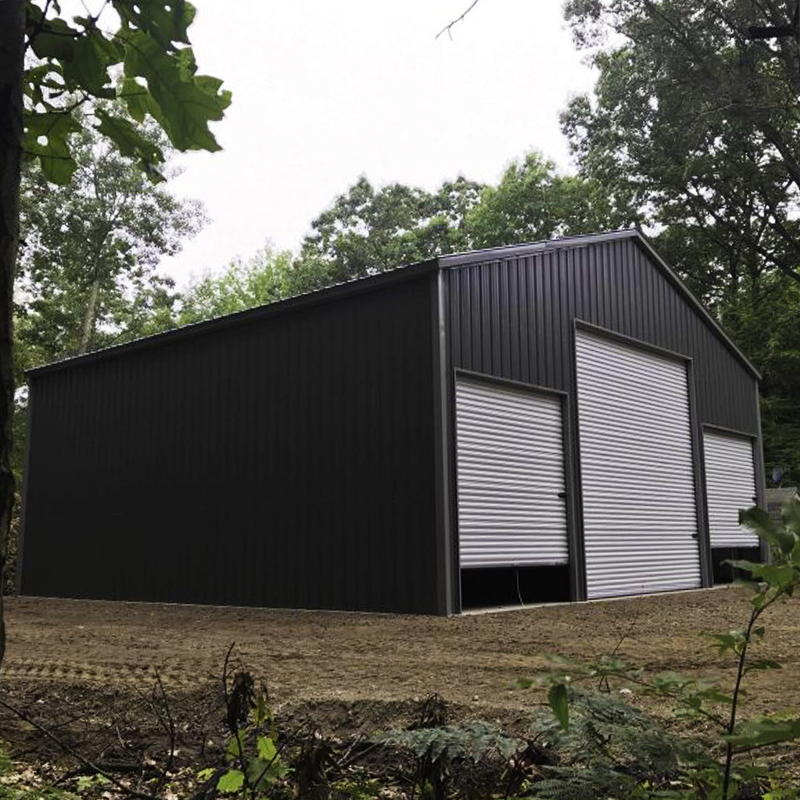 All-Vertical-Steel-Building-Charcoal A large black and white building sitting in the middle of a field.